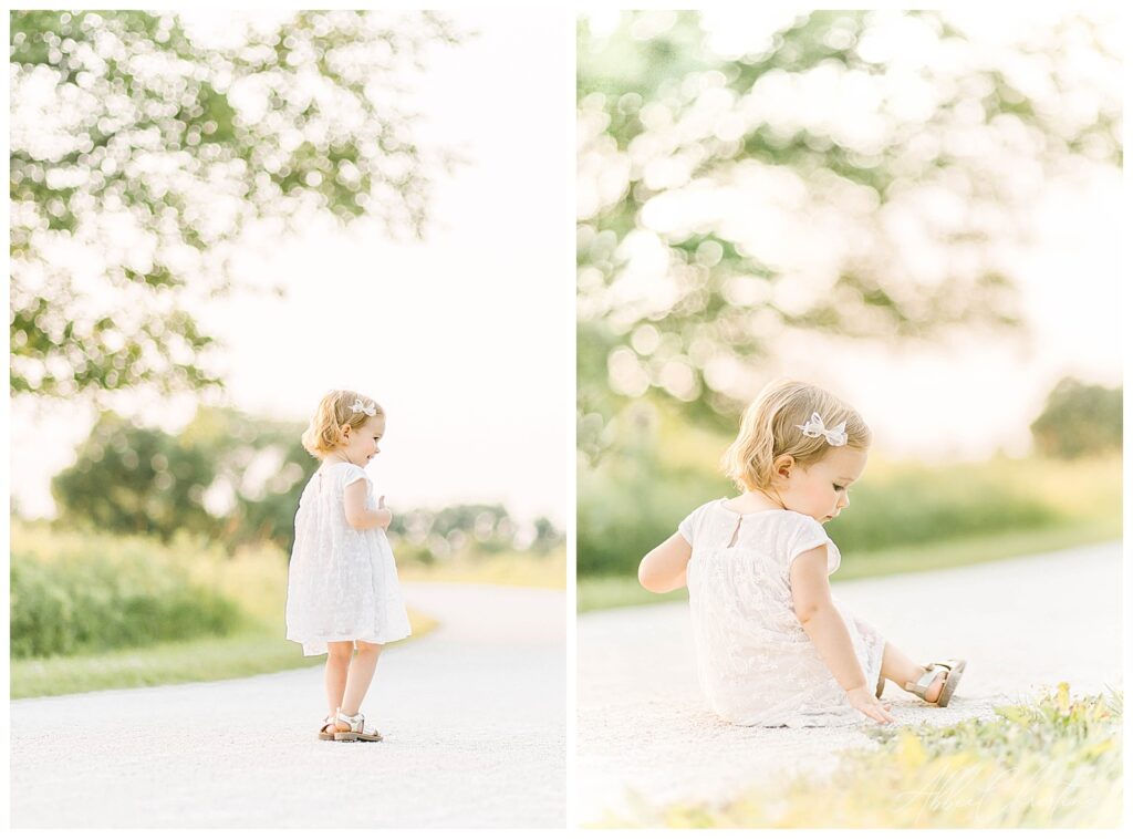 Two year old girl in white dress dances dances on gravel path near a tree in Chicago, Il. 
